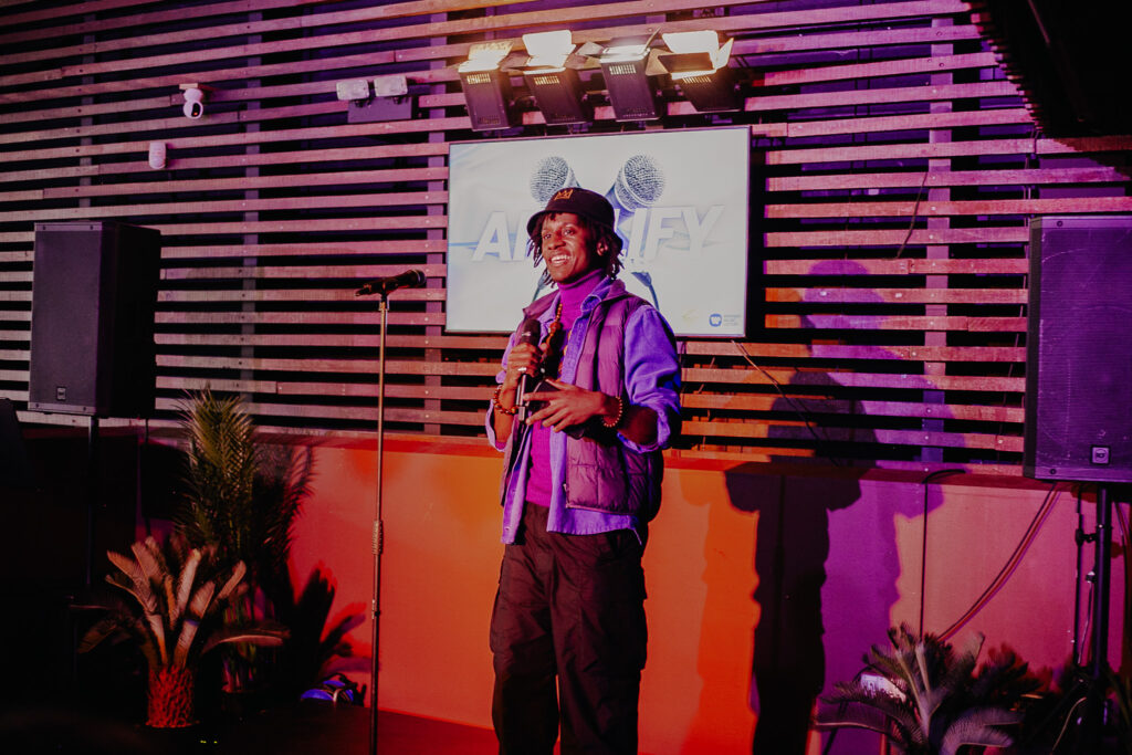 Solomon Adams speaking on stage at the AMPLIFY showcase at the Bernie Grant Arts Centre